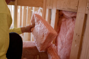 fiberglass batt insulation being installed